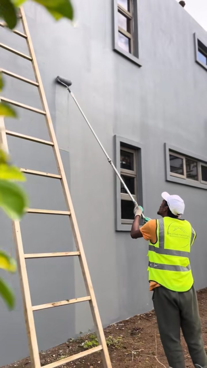 Ouvrier PTF en gilet appliquant le Polylastic au rouleau sur la façade